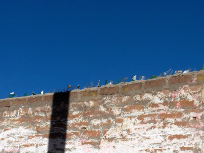 The broken glass discourages thieves from climbing over the wall